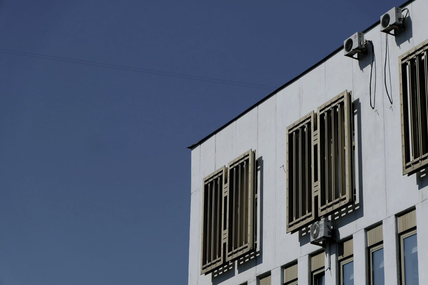 Außengerät einer Klimaanlage auf einer Konsole an einer hellen Putzfassade