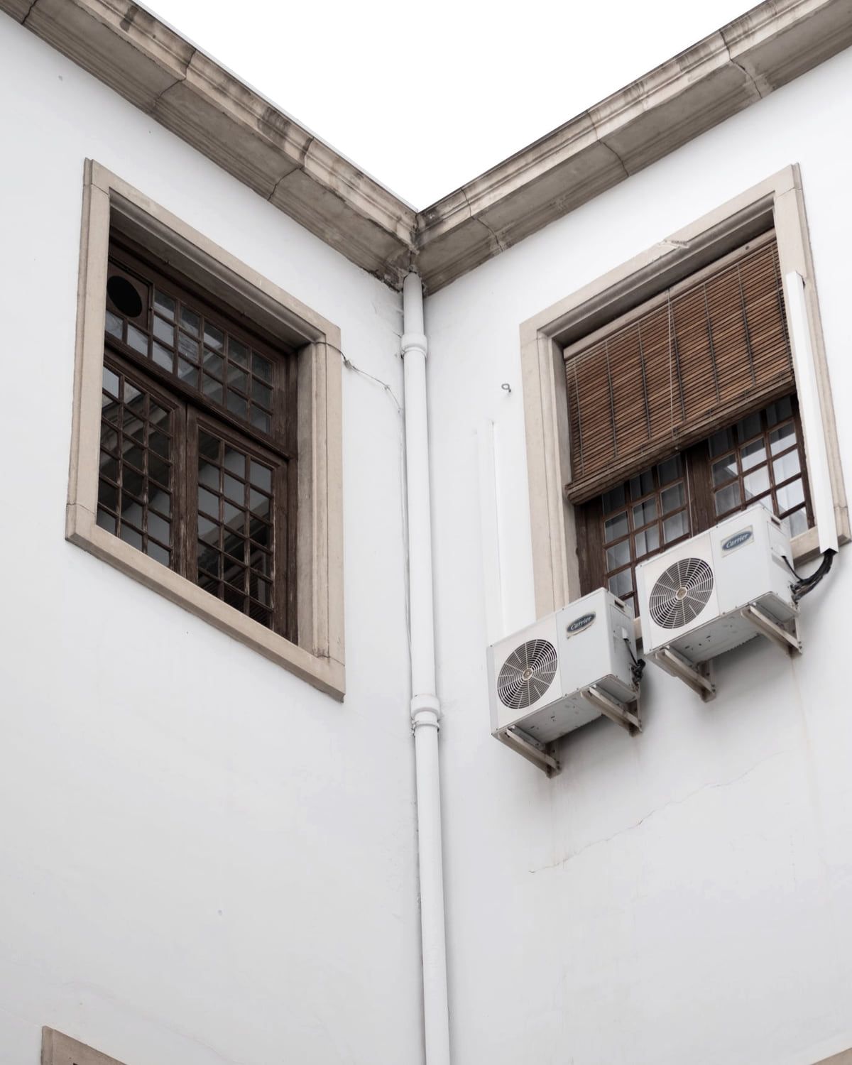 Außengerät einer Klimaanlage auf einer Wandkonsole an einer verputzten Fassade